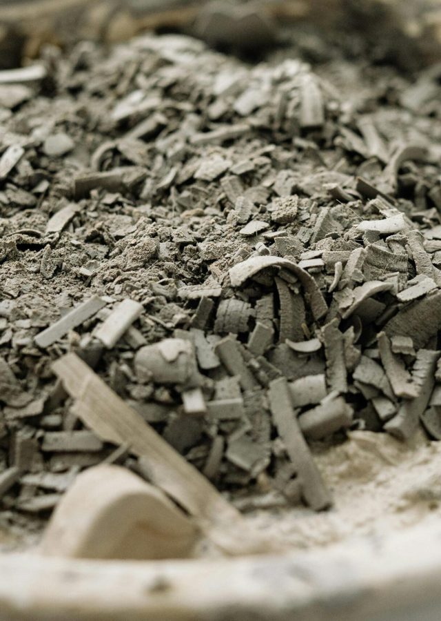 Detailed close-up of a white bowl filled with ashes and debris, highlighting texture.